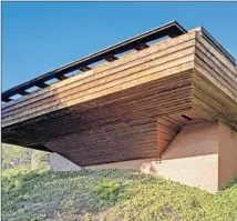  ??  ?? A 21-FOOT overhangin­g deck wraps around the two-bedroom hillside home, modestly sized at 1,200 square feet.