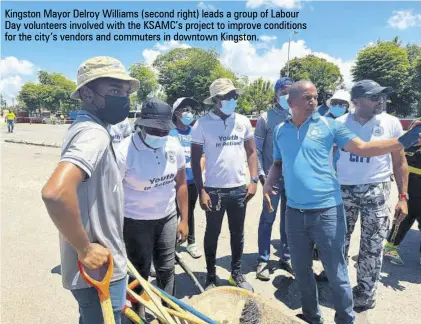  ?? ?? Kingston Mayor Delroy Williams (second right) leads a group of Labour Day volunteers involved with the KSAMC’S project to improve conditions for the city’s vendors and commuters in downtown Kingston.