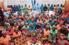  ?? AFP PIC ?? Nigerian President Muhammadu Buhari (centre) sitting among the 82 rescued Chibok girls at the Presidenti­al Villa in Abuja on Sunday.