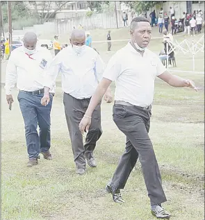  ?? ?? Mbabane Highlander­s Director Chief Ally Kgomongwe (front) walks over mud at the Prince of Wales Sports Ground on Sunday where they lost 0-1 to Vovovo FC.