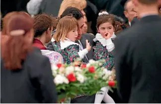  ?? PHOTO: CANBERRA TIMES ?? The funeral for Tania Furlan: Her husband, Victor, holds daughters Katrina, 5, and Sonja, 3, who wave goodbye to the hearse at St Christophe­r Cathedral in Canberra.