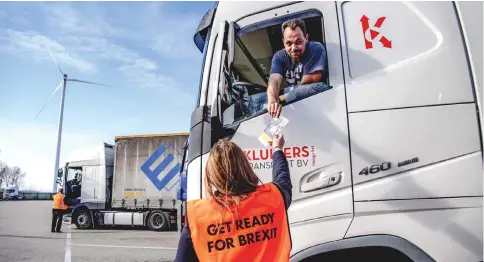  ??  ?? An employee of the Port of Rotterdam hands out flyers with informatio­n about Brexit to a truck driver at the entrance of the Stena terminal, in the port of Rotterdam. The flyers are intended to inform drivers of the formalitie­s concerning the transport of goods to Britain. – AFP photo