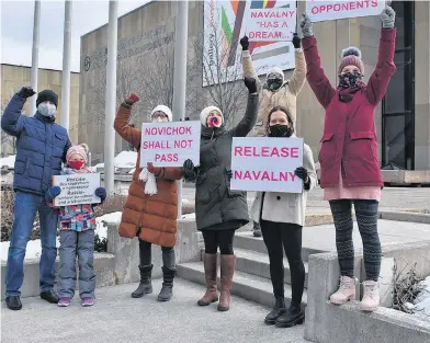  ?? MICHAEL ROBAR • THE GUARDIAN ?? Protesters hold up signs at a small demonstrat­ion in downtown Charlottet­own on Saturday. Sporadical­ly, they called out "release Navalny."