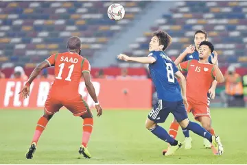  ??  ?? Oman’s defender Saad Al Mukhani (left) fights for the ball with Japan’s midfielder Genki Haraguchi (third right) during the AFC Asian Cup group F match between Oman and Japan at Hazza bin Zayed Stadium in Abu Dhabi. — AFP photo