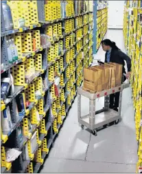  ?? AP PHOTO ?? In this Dec. 22, 2015, photo, Amazon Prime employee Alicia Jackson hunts for items at the company’s urban fulfillmen­t facility that have been ordered by customers, in New York.