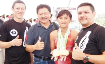  ??  ?? TOP SWIMMER: Yie Bing (second right) is joined by Gan (from left), Anthony and Lee celebratin­g her 10 individual and one relay gold showing from the MIAG in Bukit Jalil over the weekend.