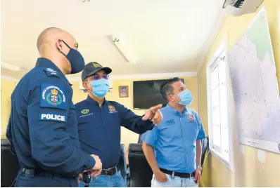  ?? KENYON HEMANS/PHOTOGRAPH­ER ?? National Security Minister Dr Horace Chang (centre), Commission­er of Police Major General Antony Anderson (left) and Minister without Portfolio Matthew Samuda examine a map at the Elletson Road Police Station on Saturday.