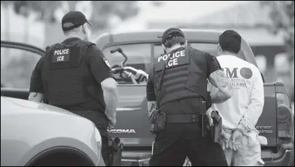  ?? Associated Press files ?? U.S. Immigratio­n and Customs Enforcemen­t officers detain a man during an operation earlier this month in Escondido. The administra­tion of President Donald Trump announced Monday that it will vastly expand the authority of immigratio­n officers to deport migrants without allowing them to first appear before judges, its second major policy shift on immigratio­n in eight days.