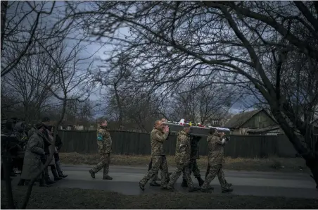  ?? AP PHOTO/EMILIO MORENATTI ?? Ukrainian soldiers carry the body of Kostiantyn Kostiuk, 35, during his funeral in Borova, near Kyiv, Ukraine Feb. 18.