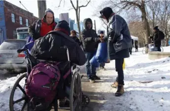  ?? LUCAS OLENIUK/TORONTO STAR ?? Good samaritan Dave Das (middle, in black) delivers 15 sleeping bags to people in need Sunday at Moss Park.