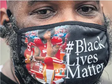  ?? ROBERTO SCHMIDT AFP VIA GETTY IMAGES ?? A protester, wearing a face mask featuring Colin Kaepernick kneeling, joins a protest in Washington against racism and police brutality on Saturday.