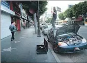  ?? Mel Melcon Los Angeles Times ?? ZACH DE LUCA plays guitar atop his car on Hollywood Boulevard, which is often closed for events.