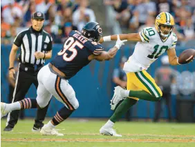  ?? ?? Packers quarterbac­k Jordan Love tries to escape the rush of Bears defensive end DeMarcus Walker on Sept. 10. BRIAN CASSELLA/CHICAGO TRIBUNE