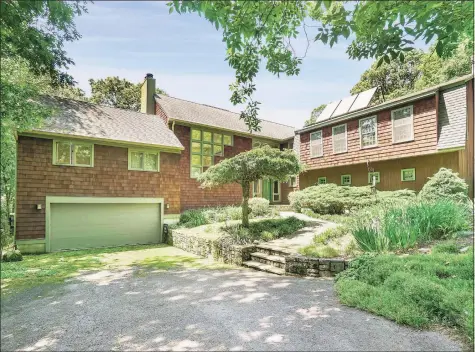  ?? Modern Angles photo ?? This 3,488 square- foot contempora­ry in Weston is set far back from the road on two acres with vibrant gardens, a stone patio, and freeform pool with spa and waterfall.