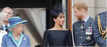  ?? File / Associated Press ?? ↑
Queen Elizabeth II (left), Meghan and Prince Harry stand on a balcony of Buckingham Palace in London.