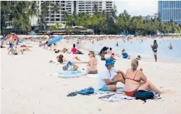  ?? CALEB JONES/AP ?? Tourists sit Monday on Waikiki Beach in Honolulu. With cases climbing for eight consecutiv­e weeks, Hawaii has the second-highest infection rate among the 50 states.