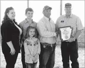  ?? Randy Moll/Westside Eagle Observer ?? Jeremy Jackson, along with his wife Michelle, son Wyatt and daughter Emily, received the Benton County Farm Family of the Year Award from Jim Singleton, chairman of the selection committee at ceremonies at the Jackson Farm on Tuesday, May 1.