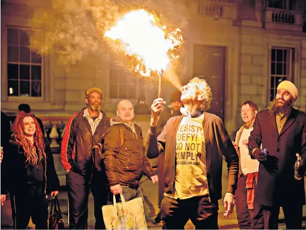  ?? ?? Piers Corbyn breaths fire during a demonstrat­ion in Westminste­r against domestic Covid-19 vaccinatio­n passports and mandatory inoculatio­ns as part of Government plans to stop the spread of the omicron variant