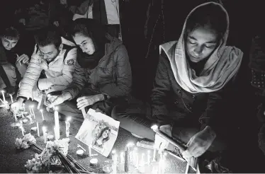  ?? Ebrahim Noroozi / Associated Press ?? People gather for a candleligh­t vigil Saturday for the victims of the Ukraine Internatio­nal Airlines Flight 752 crash. The vigil was held at the gate of Amri Kabir University, where some of the victims were former students.