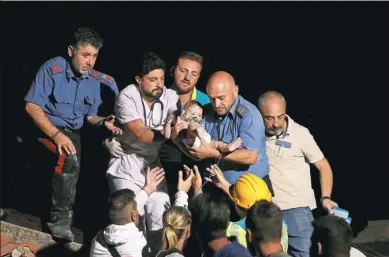  ?? ANTONIO DILAURENZO / REUTERS ?? An Italian police officer and a doctor carry a 7-month-old boy after an earthquake hit the island of Ischia off the coast of Naples, Italy. The boy’s two brothers were later also rescued.