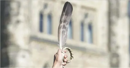  ?? ADRIAN WYLD/THE CANADIAN PRESS FILES ?? An eagle feather is held up during a rally for Missing and Murdered Indigenous Women and Girls in Ottawa in 2016. Canada is failing to promote “equal justice under law” when it comes to First Nations governance, says Diane Francis.