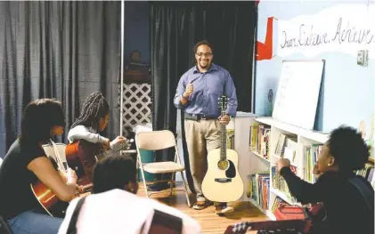  ?? STAFF PHOTOS BY ANGELA LEWIS FOSTER ?? David Yancey teaches a music-based physics lesson at Temple of Faith Deliveranc­e Church of God in Christ.