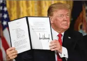  ?? ALEX WONG / GETTY IMAGES ?? U.S. President Donald Trump holds up an executive order that he signed to establish the Space Force as the sixth branch of the U.S. armed forces at the White House on Monday.