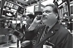  ?? Associated Press ?? ■ Trader John Santiago works Oct. 15 on the floor of the New York Stock Exchange.
