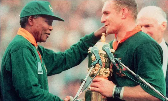  ??  ?? Simboli
Il presidente Nelson Mandela si congratula con François Pienaar, capitano degli Springbok, la squadra di rugby che era stata bandita per via dell’apartheid. Mandela impedì che il logo e il nome fossero cambiati, e invitò tutti i cittadini, bianchi e neri, a tifare per loro. Nel 1995 vinsero la Coppa del Mondo (Afp/jeanpierre Muller)