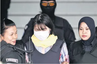  ?? AP ?? Vietnamese Doan Thi Huong, centre, is escorted by police as she leaves a court hearing at the Shah Alam High Court in Malaysia.
