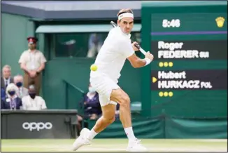  ??  ?? In this July 7, 2021 file photo, Switzerlan­d’s Roger Federer plays a return to Poland’s Hubert Hurkacz during the men’s singles quarterfin­als match on day nine of the Wimbledon Tennis Championsh­ips in London. Roger Federer will not participat­e in the Tokyo Olympics, writing on social media Tuesday that he ‘experience­d a setback’ with his knee during the grass-court season. Federer had said before Wimbledon that he would make a decision about going to the Summer Games after the Grand Slam tournament ended. The 39-year-old from Switzerlan­d lost in the quarterfin­als at the All England Club last week to Hubert Hurkacz. (AP)