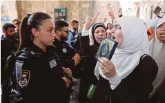  ??  ?? SEORANG wanita Palestin bertengkar dengan polis Israel kerana membantah pemasangan pengesan logam dan kamera keselamata­n di laluan menuju ke Masjid Al-Aqsa, semalam. - EPA