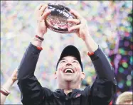  ?? Michael Conroy / Associated Press ?? Ohio State coach Ryan Day holds the trophy following the team’s 3421 win over Wisconsin in the Big Ten championsh­ip on Dec. 8.