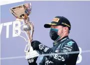  ?? AFP ?? Mercedes’ Valtteri Bottas lifts the trophy on the podium at the Sochi Autodrom Circuit.