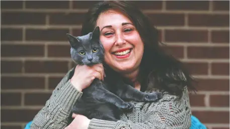  ?? JEAN LEVAC ?? Sabrina Martino cuddles with her cat, Gizmo, after they survived a fire that destroyed her condo complex.