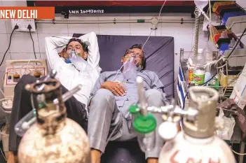  ?? Reuters ?? ■ Patients suffering from Covid-19 share a bed as they undergo treatment at the casualty ward in Lok Nayak Jai Prakash hospital in New Delhi yesterday.