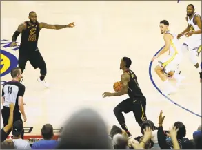  ?? Lachlan Cunningham / Getty Images ?? J. R. Smith dribbles in the closing seconds of regulation as LeBron James, left, attempts to direct him back to the basket during Game 1 of the NBA Finals on Thursday.