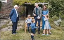  ?? KENSINGTON PALACE VIA AP ?? Britain’s Prince William, center, Kate, the Duchess of Cambridge, react with Naturalist David Attenborou­gh, left, with their children, Prince George, seated, Princess Charlotte, right and Prince Louis, foreground, in the gardens of Kensington Palace in London after Prince William joined Attenborou­gh to watch a private outdoor screening of his upcoming film - David Attenborou­gh: A Life On Our Planet.