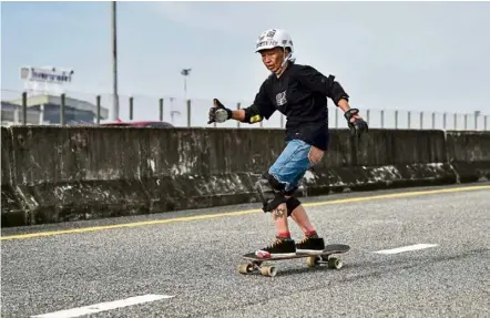  ??  ?? Healing wheels: Jeab boarding along a stretch of an unfinished highway in Bangkok.