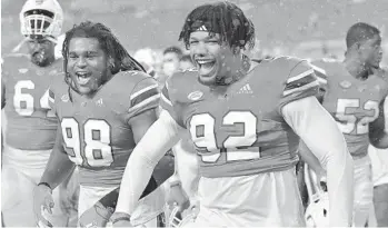  ?? MICHAEL LAUGHLIN/SOUTH FLORIDA SUN SENTINEL ?? Miami linemen Jalar Holley, 98, and Jason Blissett Jr. celebrate beating Virginia 19-14 on Oct. 24. Blissett announced Monday that he is retiring from football due to suffering multiple head injuries.