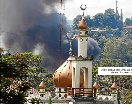  ?? —REUTERS ?? Smoke billows near a mosque in Marawi City.