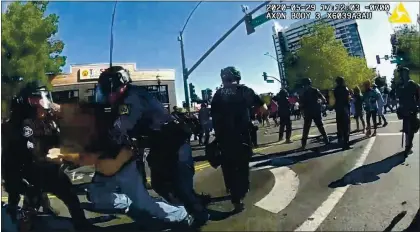  ?? SAN JOSE POLICE DEPARTMENT ?? In a frame from a San Jose police officer’s bodycam video, officers arrest a man, whose face is obscured in the video, during a San Jose protest May 29. Police allege the man attempted and failed to disarm an officer following the declaratio­n that the protest was an unlawful assembly.