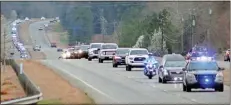  ?? Jeremy stewart ?? A line of patrol cars from several law enforcent agencies travel on Ga. 1 North just outside of Cedartown as part of the funeral procession for Polk County Sheriff’s Office Sgt. Barry Henderson on Saturday, March 13, 2021.