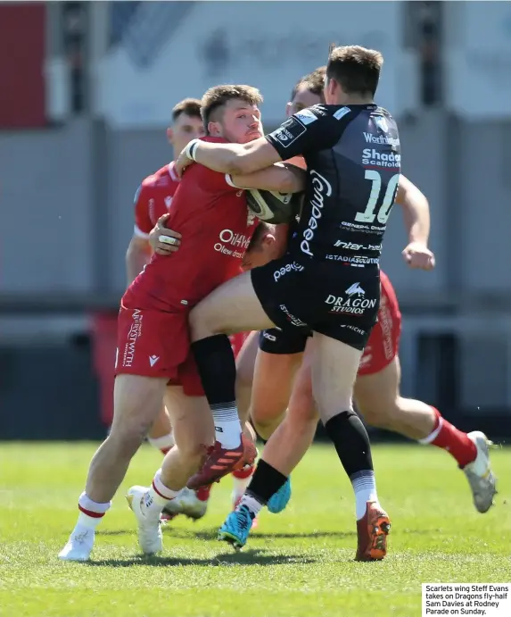  ??  ?? Scarlets wing Steff Evans takes on Dragons fly-half Sam Davies at Rodney Parade on Sunday.