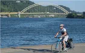  ?? Pittsburgh Post-Gazette ?? Shaler High School teacher Adam Rosenwald at Point State Park, beginning a six-day bike ride to Washington D.C. along the Great Allegheny Passage trail.