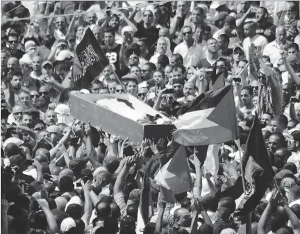  ?? MAHMOUD ILLEAN/ THE ASSOCIATED PRESS ?? Palestinia­ns carry the body of a 16-year-old Mohammed Abu Khdeir in Jerusalem on Friday. Thousands of people converged on a cemetery for the burial of Abu Khdeir, whom Palestinia­ns say was killed by Israeli extremists in a suspected revenge attack.