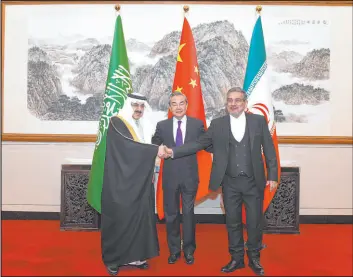  ?? Luo Xiaoguang
Xinhua News Agency ?? Iranian security official Ali Shamkhani, right, shakes hands with Saudi security adviser Musaad bin Mohammed al-aiban as Chinese diplomat Chwang Yi looks on in Beijing.