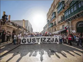  ?? RENE ROSSIGNAUD / ASSOCIATED PRESS ?? Demonstrat­ors on Sunday in Valletta, the capital city of Malta, hold a banner reading “Justice” as they hold a rally in honor of crusading Maltese journalist Daphne Caruana Galizia, who was killed by a car bomb Oct. 16.