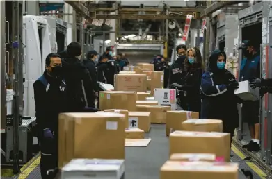  ?? JAE C. HONG/AP 2021 ?? Employees sort packages for delivery at the FedEx regional hub at the Los Angeles Internatio­nal Airport.