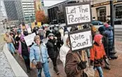  ?? KYLE ROBERTSON/AP ?? Protesters against Donald Trump march outside the Ohio statehouse before Electoral College members vote.